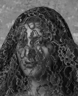 Adult woman’s face seen through a lace veil